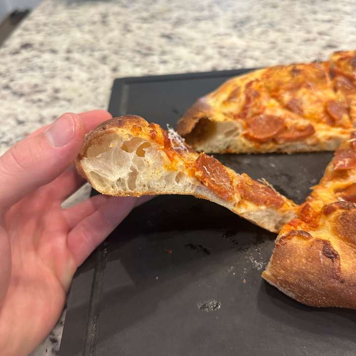 Side view of slice pizza with airy crust